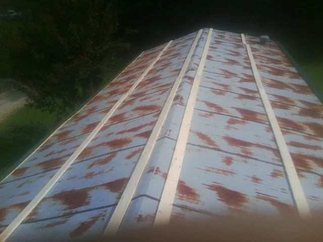 Rusted metal roof panels with new wood purlins before replacement — Storm Damage Roof Repair in Deer Lodge by Roofing Brothers