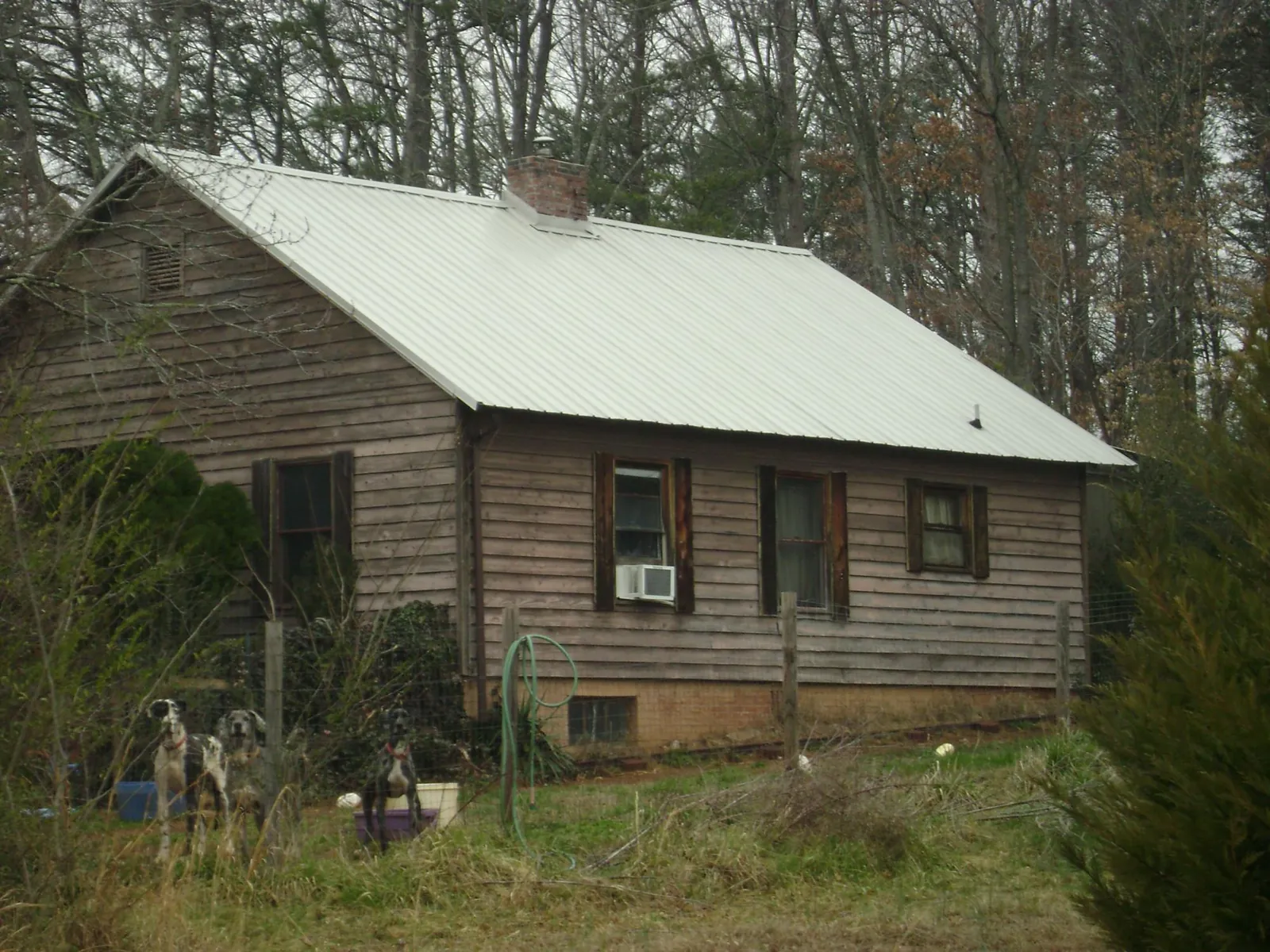 White metal roof on an old wood sided farmhouse, from a Metal Roof Installation job in Deer Lodge